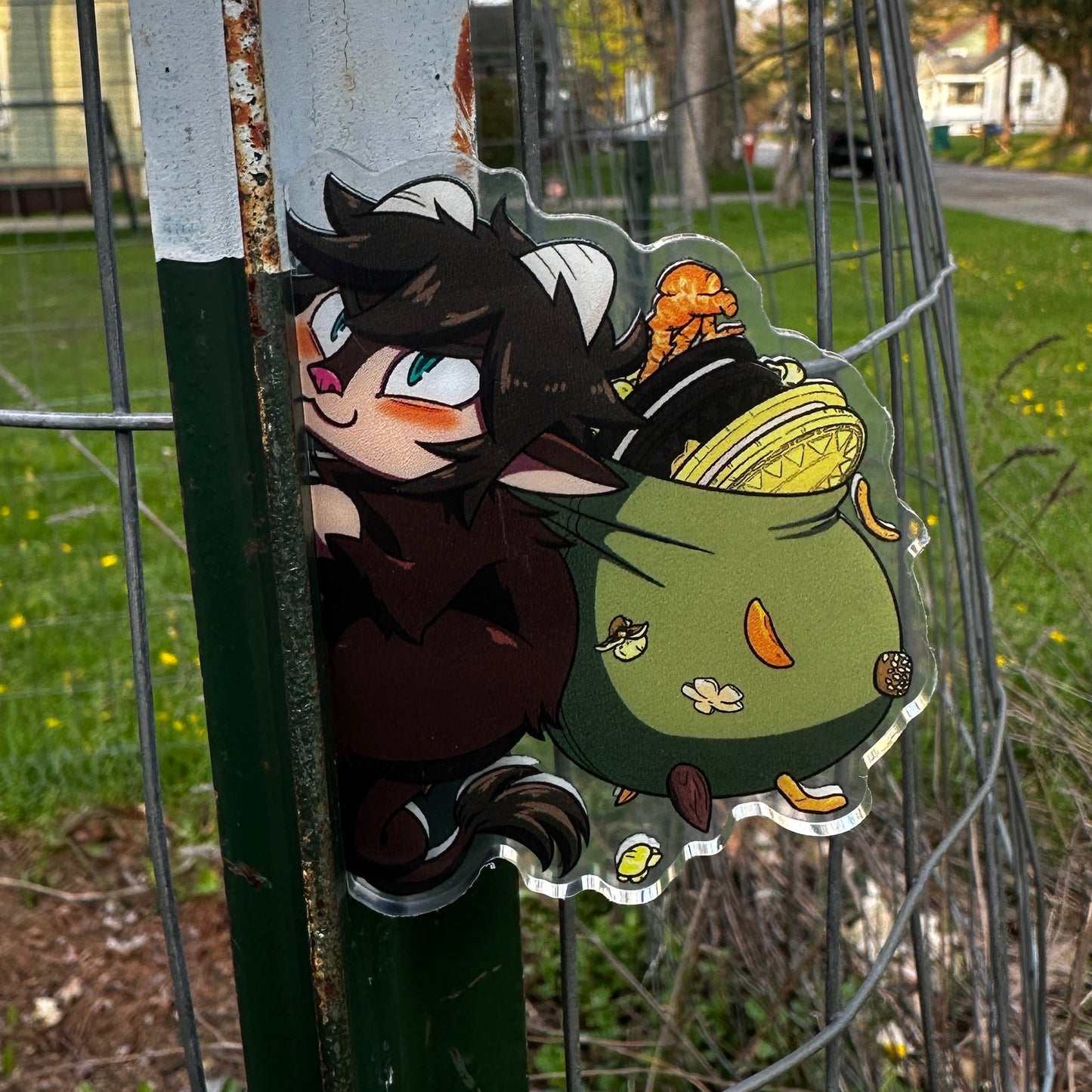 Cartoon character on a metal fence with a garden and house in the background