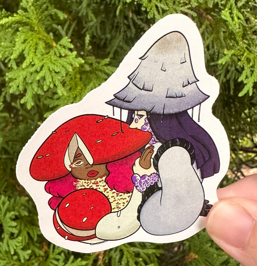 Sticker of two cartoon characters with mushroom hats held in front of green foliage