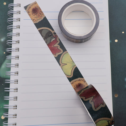 Roll of washi tape on a journal page featuring a snail and fall flowers and leaves