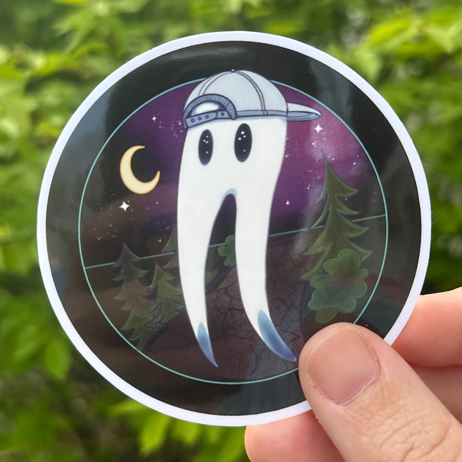 sticker of a Fresno Nightcrawler with a backwards hat in a forest scene. background is a green bush.