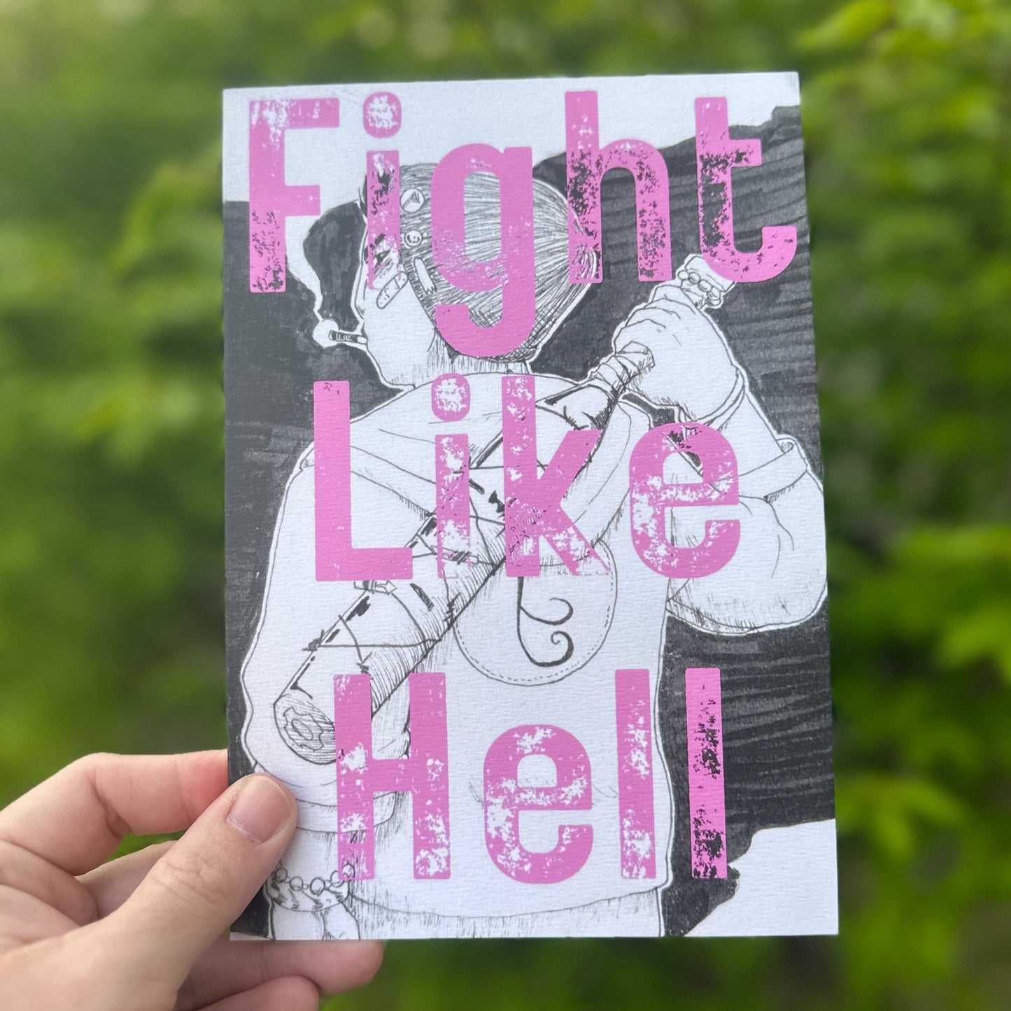 Print of a person holding a bat with the words Fight Like Hell. green bush in the background