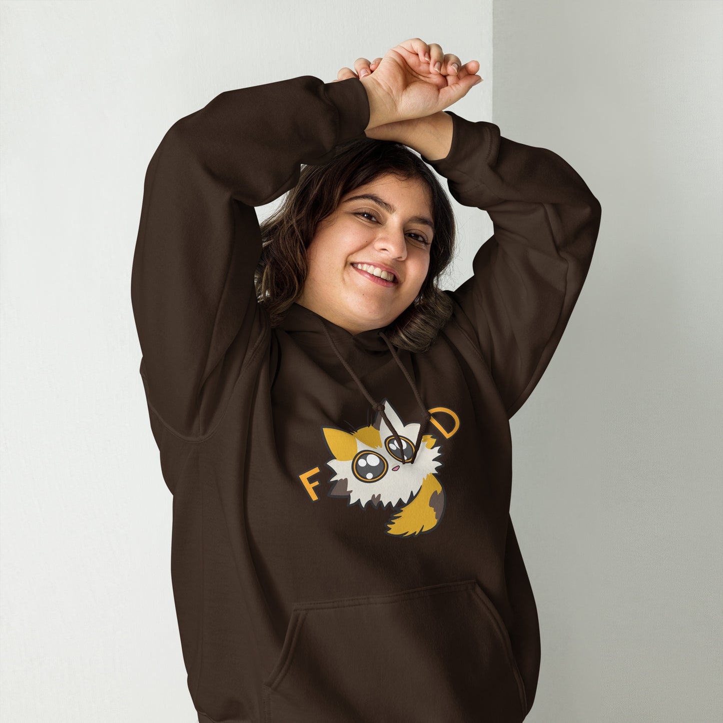 Person wearing a brown hoodie with a graphic design of a cartoon cat on a plain background