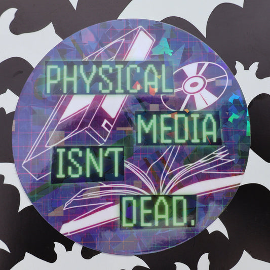 physical media isn't dead text on round holographic sticker with vhs, cd, and book tumbling in the background
