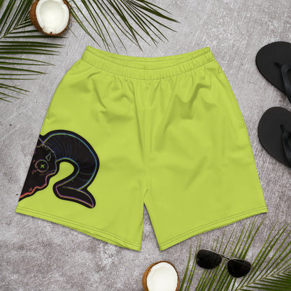 A pair of neon green unisex athletic long shorts with a graphic of a ram skull on the right leg, displayed on a coconut tree background with palm leaves and sunglasses.