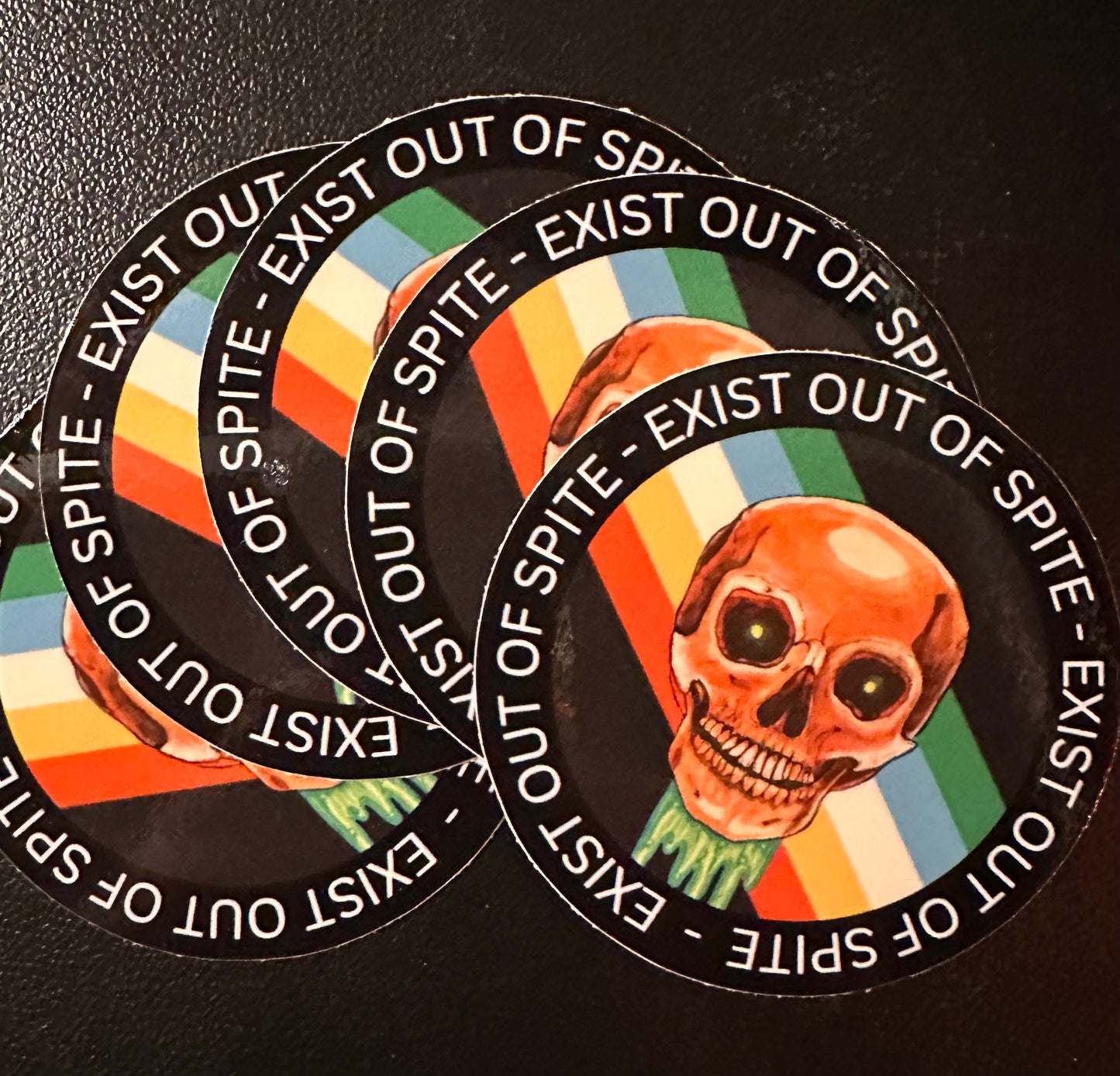 Round sticker 5 pack with a skull over a disabled pride flag encircled by the text exist out of spite