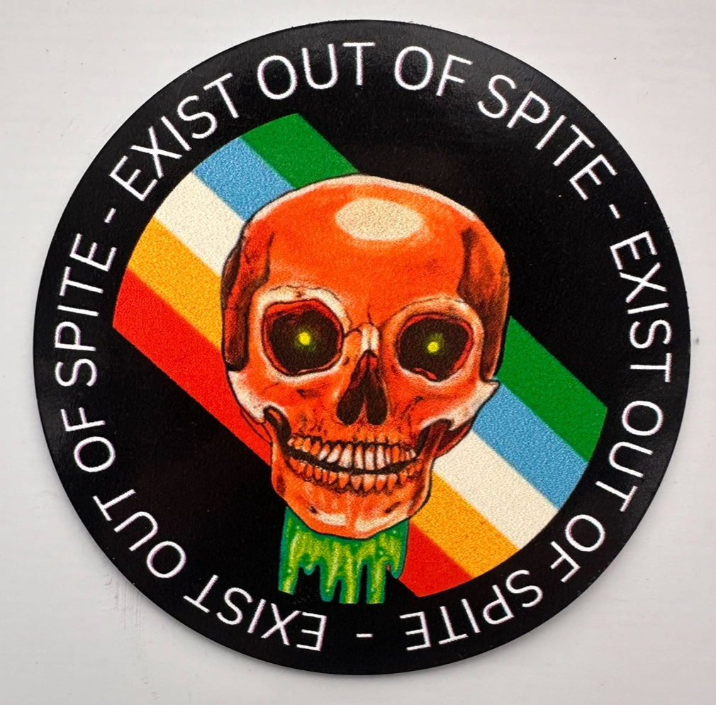 Round magnet with a skull over a disabled pride flag encircled by the text exist out of spite