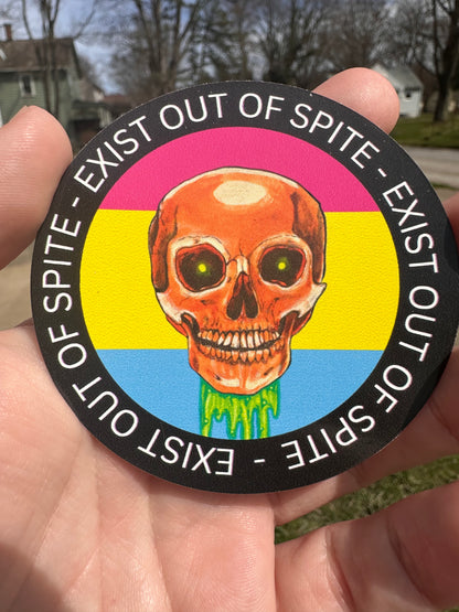 Round sticker with a skull over a pansexual pride flag encircled by the text exist out of spite